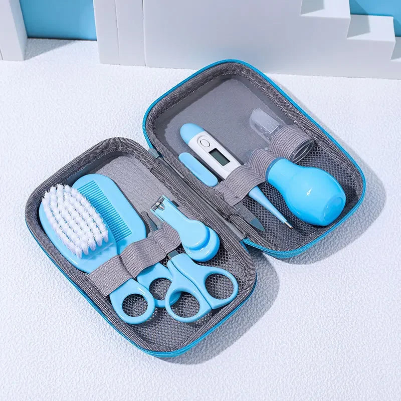 A Baby Care Kit containing a nasal suction device, toothbrush, hair brush, body heat detector, nail clipper, scissors, comb, and nail file, all in pink color, displayed in an open gray case with a blue background.