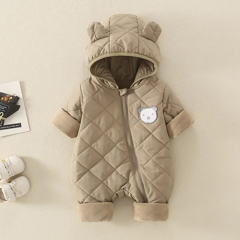 Quilted baby snowsuit with bear ears and face on a beige background