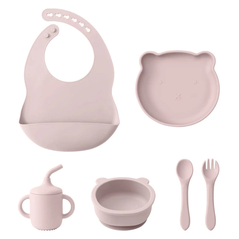 A set of baby feeding supplies in yellow, including a bib, plate, bowl, cup, and utensils with a suction base.