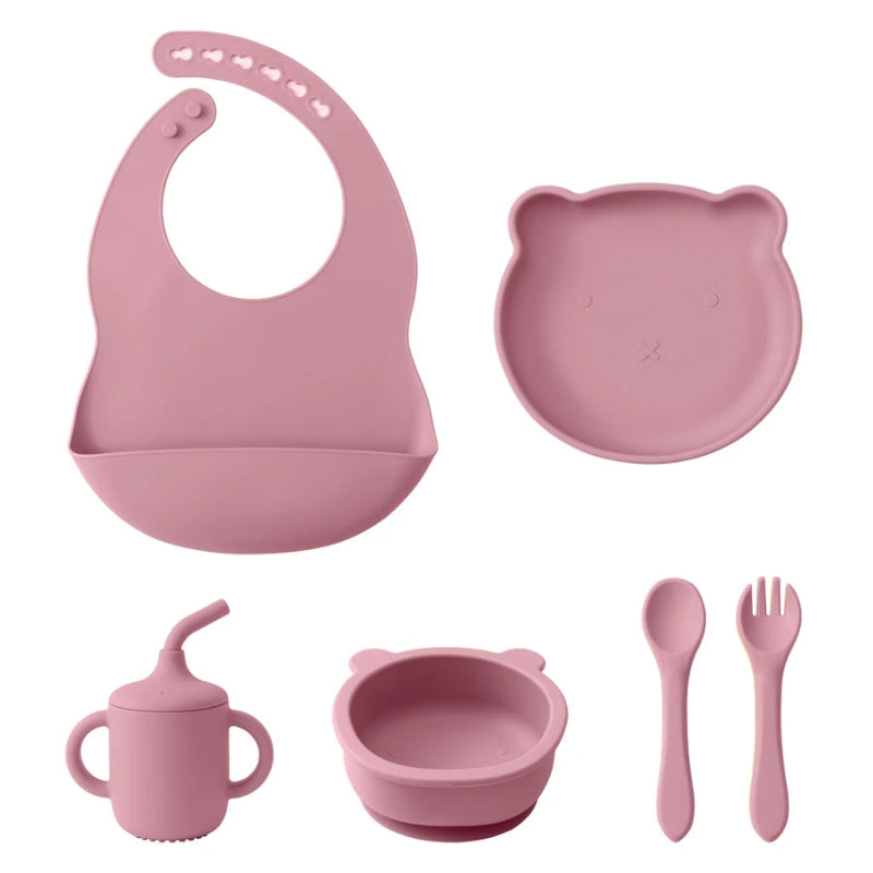 A set of baby feeding supplies in yellow, including a bib, plate, bowl, cup, and utensils with a suction base.