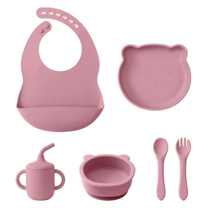 A set of baby feeding supplies in yellow, including a bib, plate, bowl, cup, and utensils with a suction base.