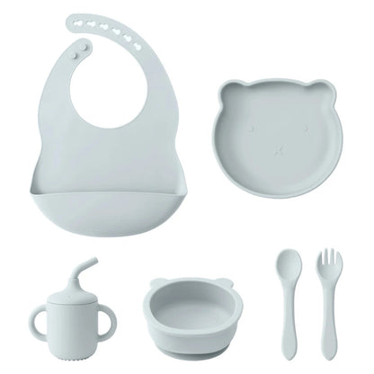A set of baby feeding supplies in yellow, including a bib, plate, bowl, cup, and utensils with a suction base.