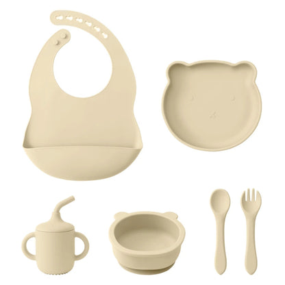 A set of baby feeding supplies in yellow, including a bib, plate, bowl, cup, and utensils with a suction base.