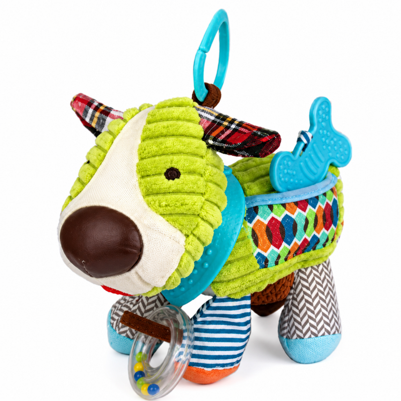 A colorful dog-shaped baby sensory toy with textured lime green fabric, patterned accents, and a blue hanging ring, photographed on a clean white background.