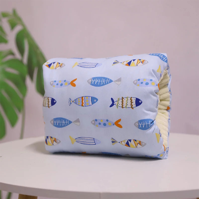 A multicolored nursing arm pillow with a pattern featuring animals and leaves.