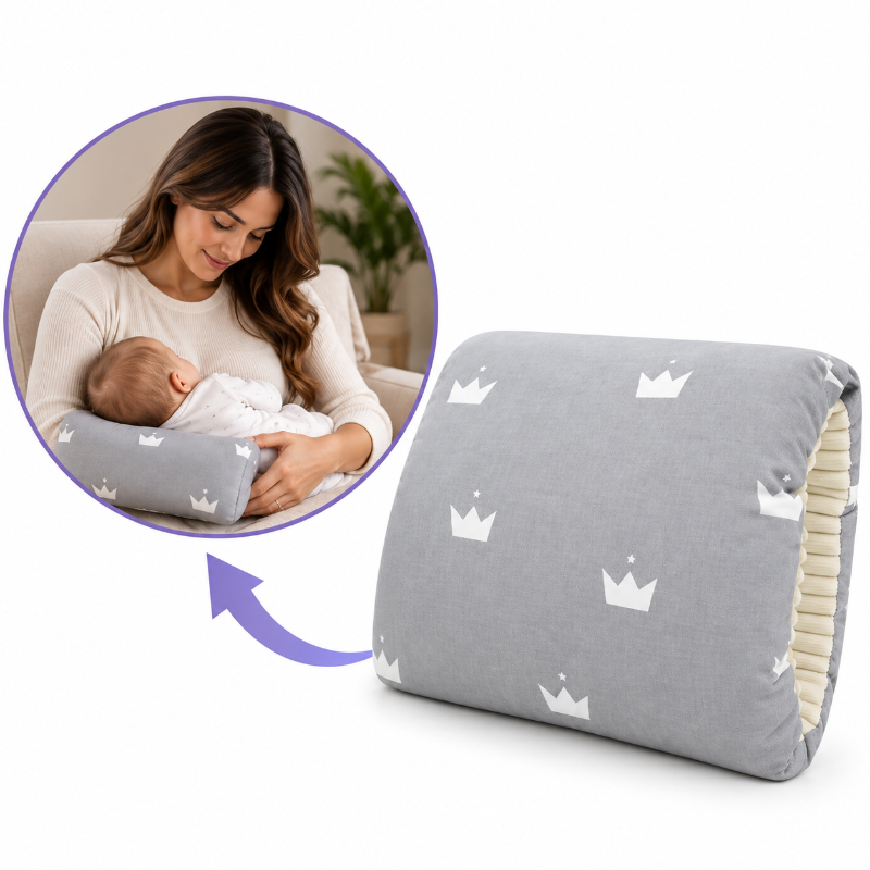 A gray nursing pillow with a white crown pattern, shown alongside a circular inset photo of a woman breastfeeding a baby while using the pillow. A purple arrow points from the inset to the main product on a white background.