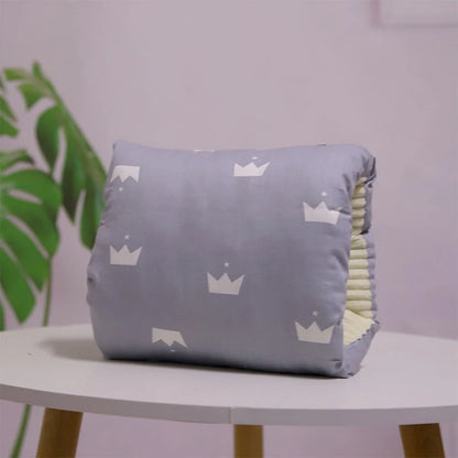 A multicolored nursing arm pillow with a pattern featuring animals and leaves.