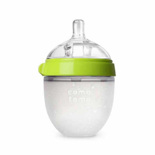 Clear baby bottle with green lid on a white background