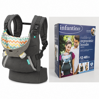 Infantino Cuddle Up Ergonomic Hoodie Carrier in dark gray fabric with a colorful chevron-patterned hood, shown next to its retail packaging box on a white background.