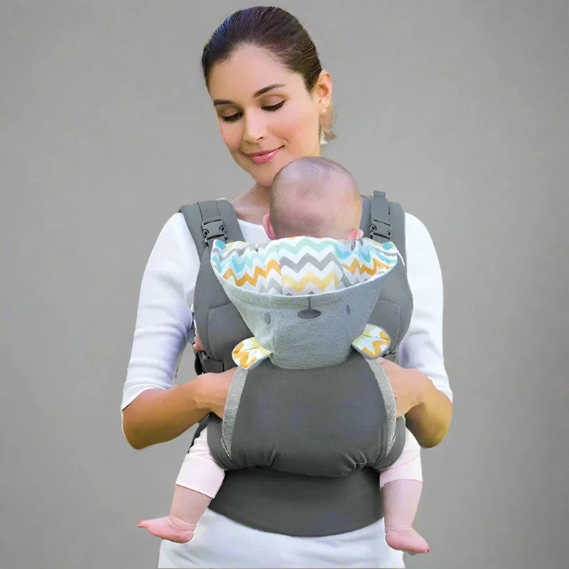 A person is seen wearing a gray ergonomic cotton baby carrier with a geometric pattern, holding a sleeping baby securely inside.