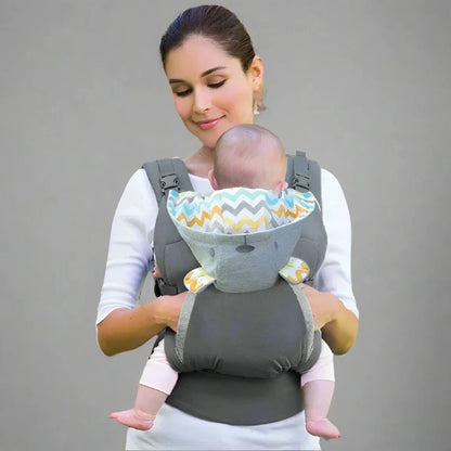 A person is seen wearing a gray ergonomic cotton baby carrier with a geometric pattern, holding a sleeping baby securely inside.