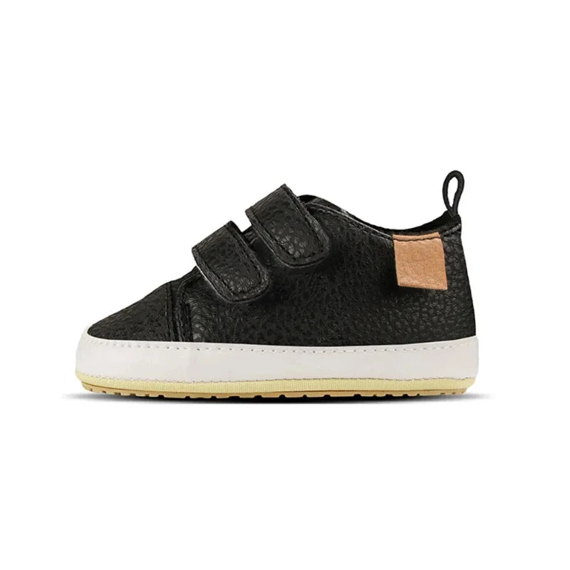 A pair of beige baby sneakers with hook and loop closure and a non-slip sole, designed for comfort and ease of wear for young children.