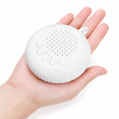 A small white portable speaker with a ribbed oval body, four round buttons, and a perforated front grille, shown resting on an open hand against a plain white background.